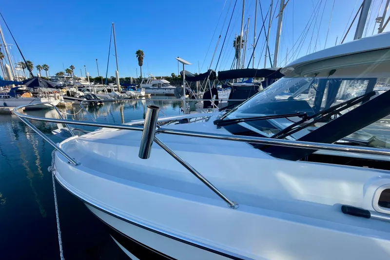 Slide: The Image of 2020 Beneteau Antares 9 docked in a marina, surrounded by sailboats. - 28