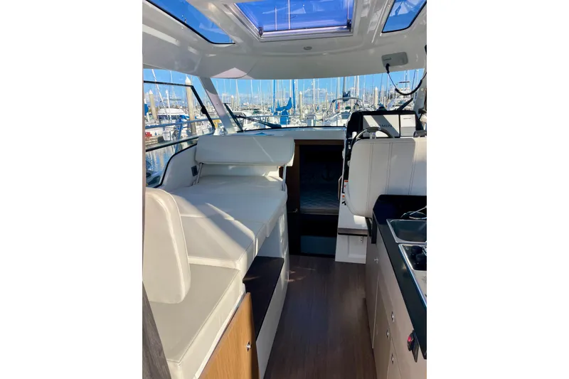 Slide: The Image of Interior of 2020 Beneteau Antares 9 boat with seating and kitchenette, docked at marina. - 6