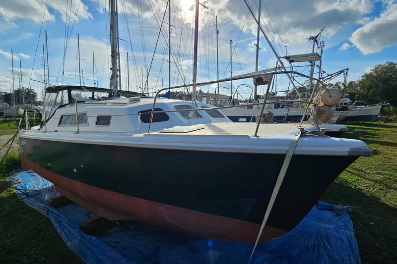 Slide: The Image of 1973 Prout 35 catamaran on land, with maintenance supplies nearby. - 1