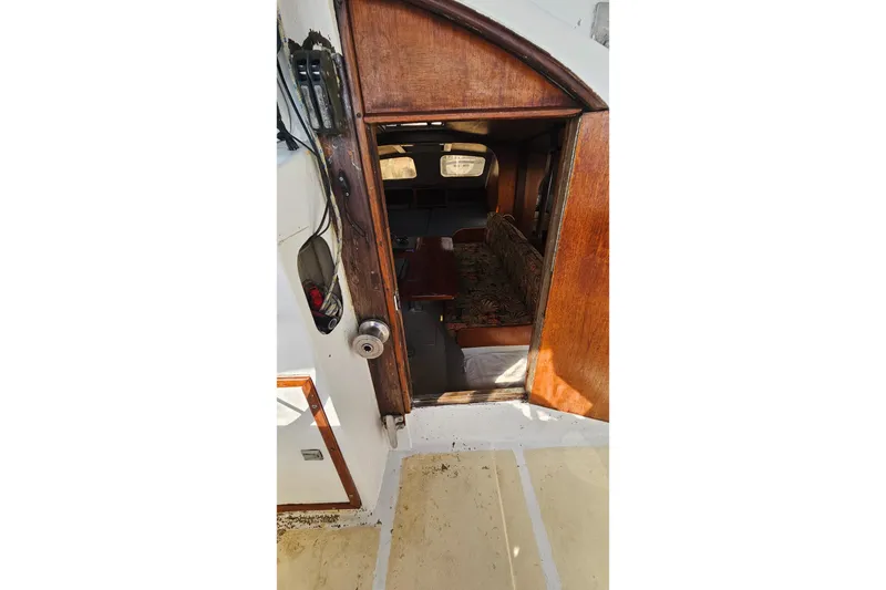 Slide: The Image of Interior of a 1973 Prout 35 boat with laptops, fan, and floral seating. - 14