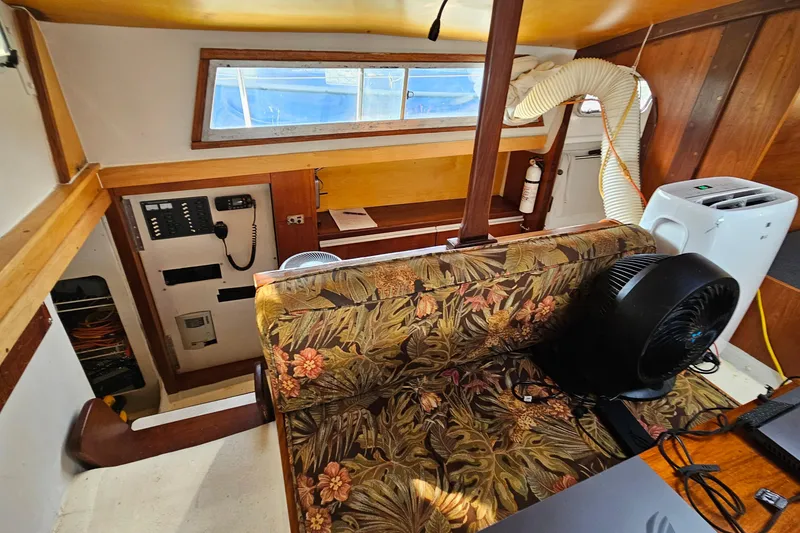 Slide: The Image of 1973 Prout 35 yacht interior with floral upholstery, compact kitchen, and wooden accents. - 17