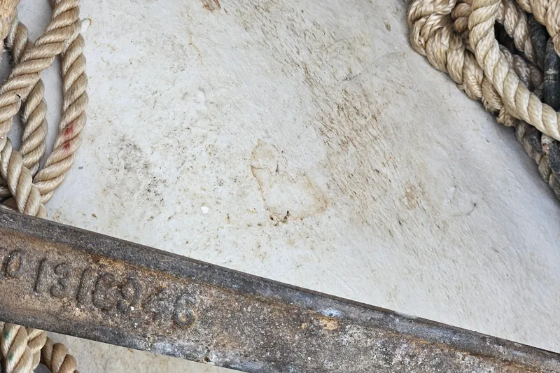 Slide: The Image of 1973 Prout 35 catamaran on land, showing hull and rudder, with blue tarp underneath. - 31