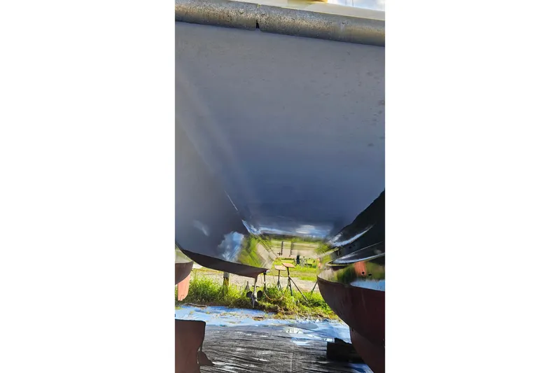 Slide: The Image of 1973 Prout 35 sailboat with green canopy, docked among other boats. - 34