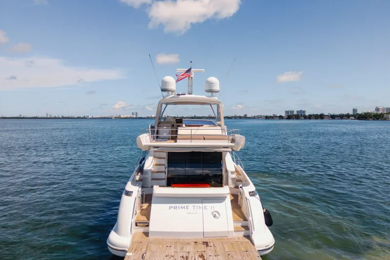 Slide: The Image of Azimut 64 Flybridge 2016 yacht on calm water with city skyline in background. - 5