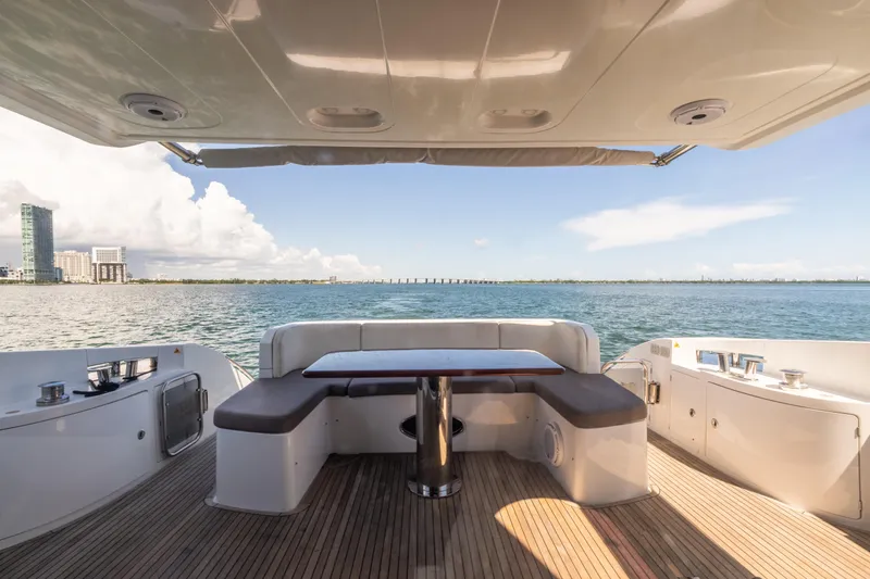 Slide: The Image of 2016 Azimut 64 Flybridge yacht deck with seating, overlooking ocean and city skyline. - 9