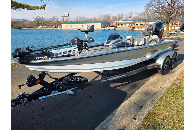 Slide: The Image of 2023 Vexus AVX1980 boat on trailer by a lake, featuring Minn Kota motor. - 9