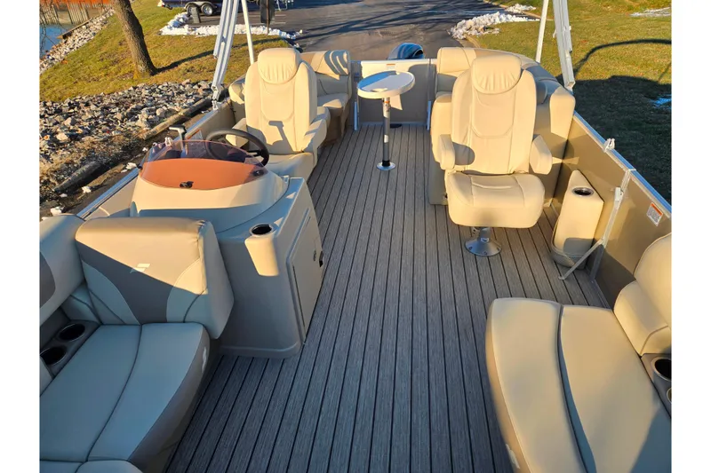 Slide: The Image of 2021 Starcraft EX 20 R pontoon boat interior with beige seating and steering console. - 10