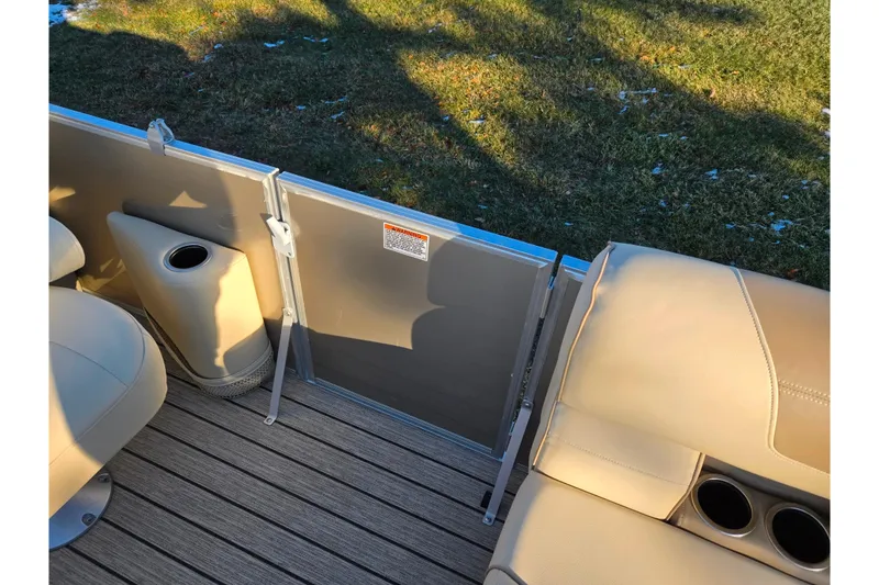 Slide: The Image of Interior view of 2021 Starcraft EX 20 R pontoon boat with beige seating and cup holders. - 11