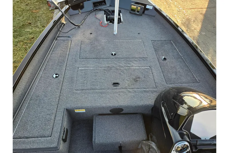 Slide: The Image of 2023 Lowe Stinger 175C boat interior with carpeted deck and storage compartments. - 13