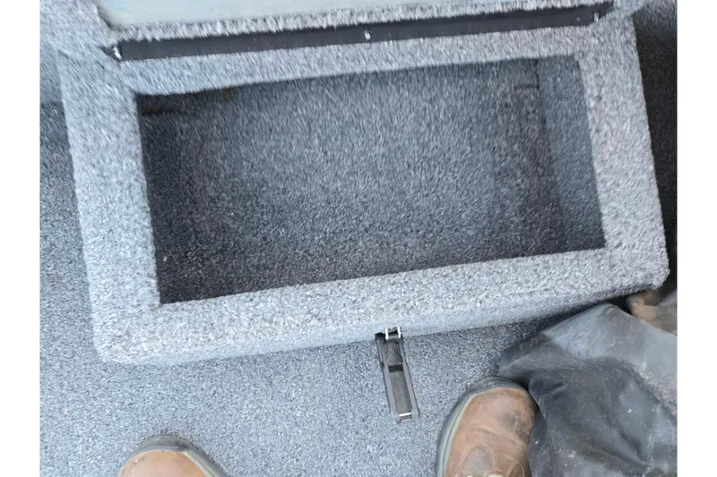 Slide: The Image of Carpeted storage compartment in a 2023 Lowe Stinger 175C boat interior. - 14
