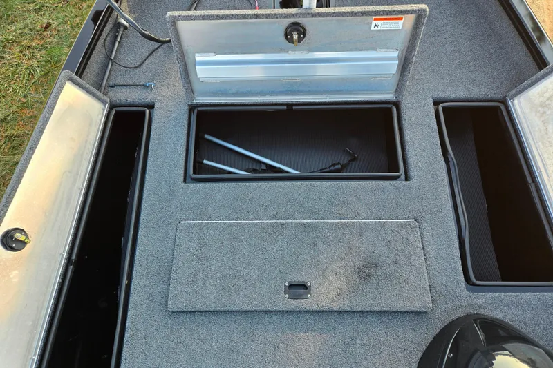 Slide: The Image of 2023 Lowe Stinger 175C boat storage compartments with open lids, showcasing interior space. - 15