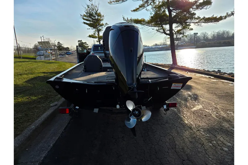 Slide: The Image of 2023 Lowe Stinger 175C boat parked by a scenic lakeside at sunset. - 2