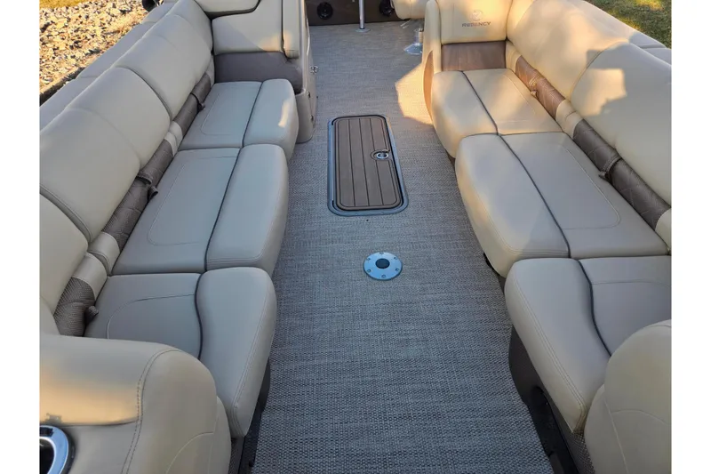 Slide: The Image of 2024 Regency 250 LE3 Sport boat interior with beige seating and carpeted floor. - 11