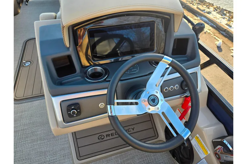 Slide: The Image of 2024 Regency 250 LE3 Sport boat dashboard with steering wheel and digital display. - 21