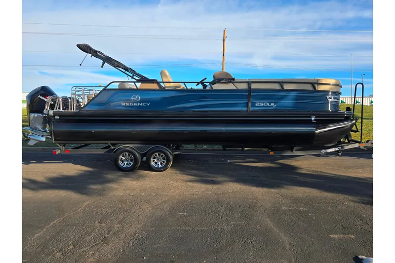 Slide: The Image of 2024 Regency 250 LE3 Sport pontoon boat on trailer, parked outdoors under blue sky. - 4