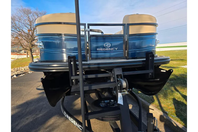 Slide: The Image of 2024 Regency 250 LE3 Sport pontoon boat on trailer, blue and beige exterior. - 6