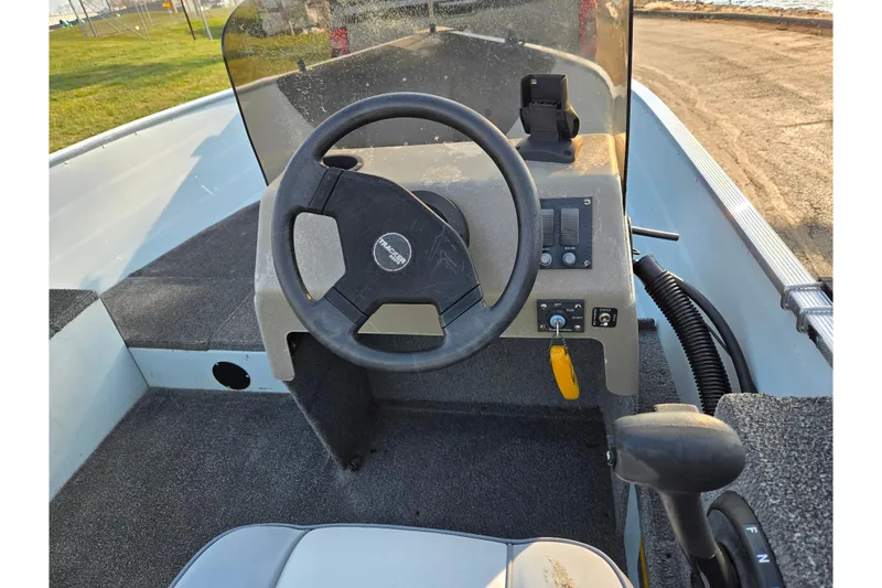 Slide: The Image of 1994 Tracker Pro Deep V-16 boat dashboard with steering wheel and controls. - 17