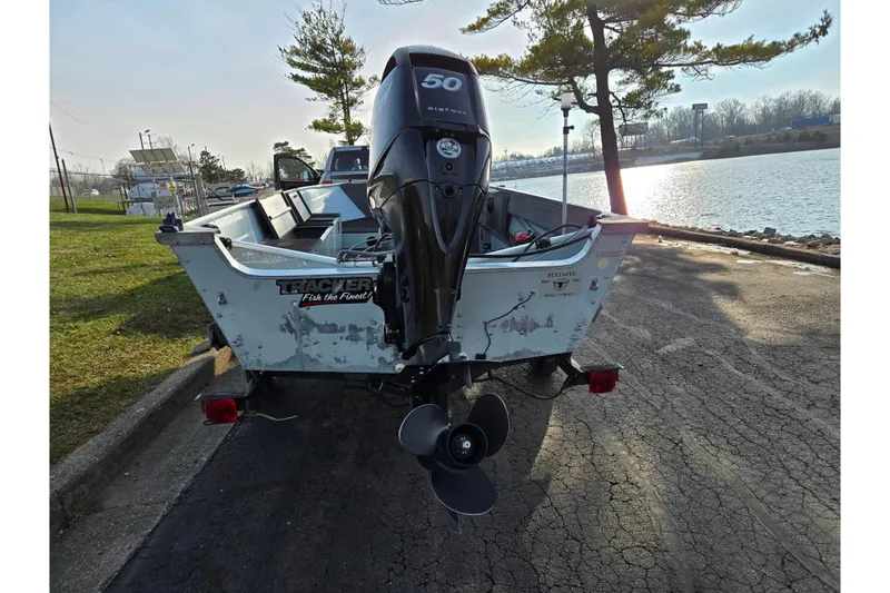 Slide: The Image of 1994 Tracker Pro Deep V-16 boat with outboard motor by a lakeside. - 2