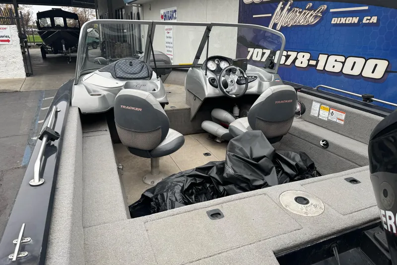 Slide: The Image of 2010 Tracker Targa 17 boat interior with seating and dashboard, parked at a marine service center. - 10