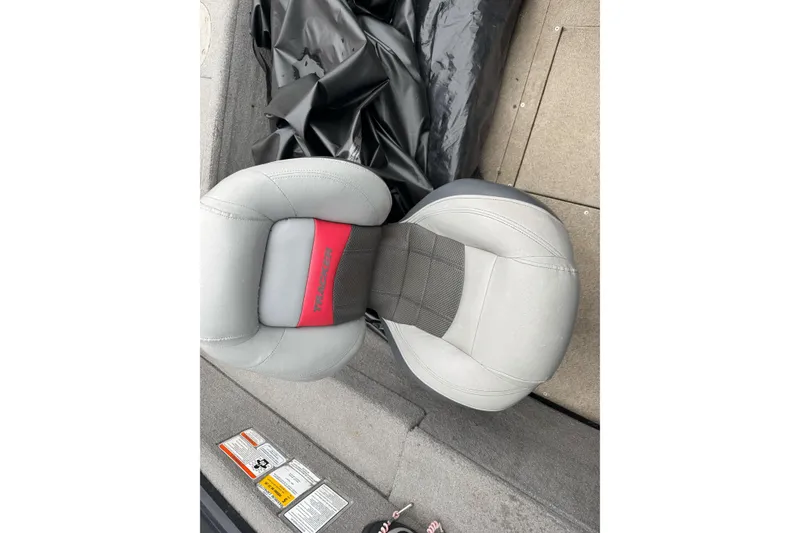 Slide: The Image of 2010 Tracker Targa 17 boat seat with gray and red design, on carpeted floor. - 15