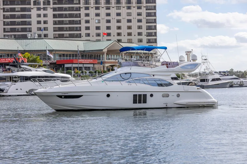 The Image of 2012 Azimut 48 Flybridge yacht docked in a marina with buildings in the background. - 0
