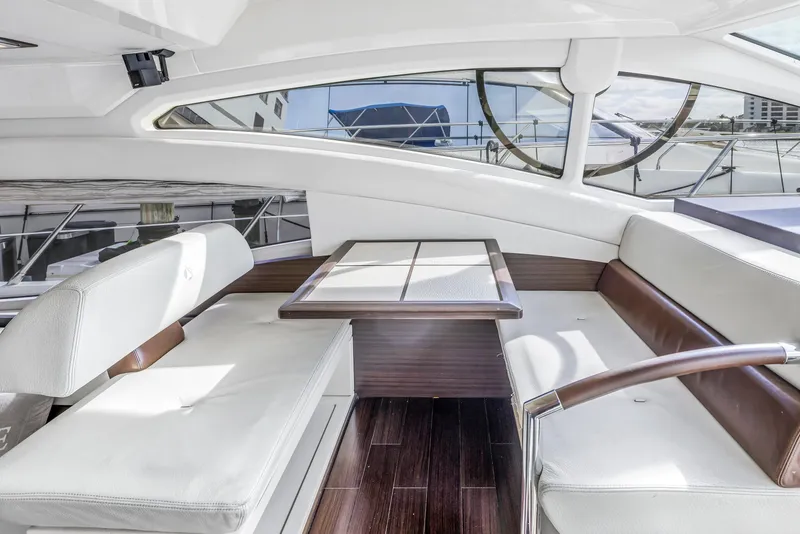 Slide: The Image of Interior seating area of 2012 Azimut 48 Flybridge yacht with white cushions and wooden table. - 18