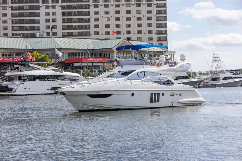 Slide: The Image of 2012 Azimut 48 Flybridge yacht docked in a marina with other boats. - 2
