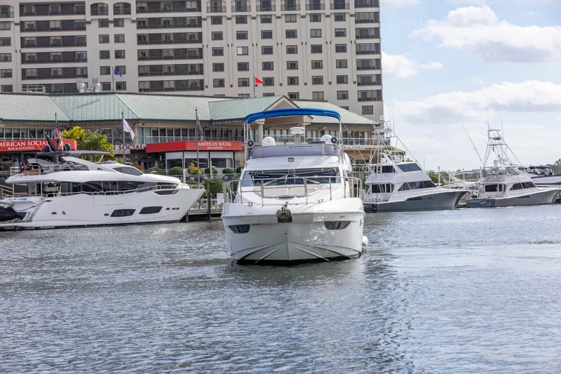 Slide: The Image of Azimut 48 Flybridge 2012 yacht docked at a marina with other boats and buildings in the background. - 4