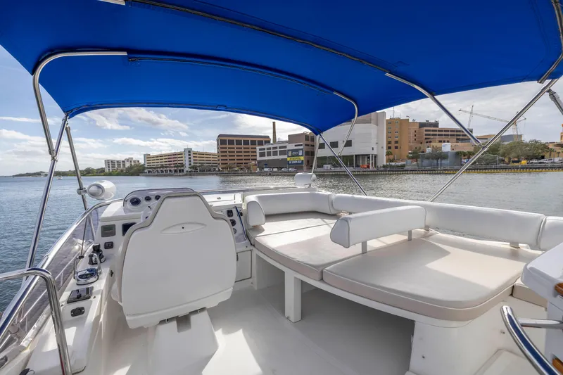 Slide: The Image of 2012 Azimut 48 Flybridge yacht with blue canopy and white seating. - 42