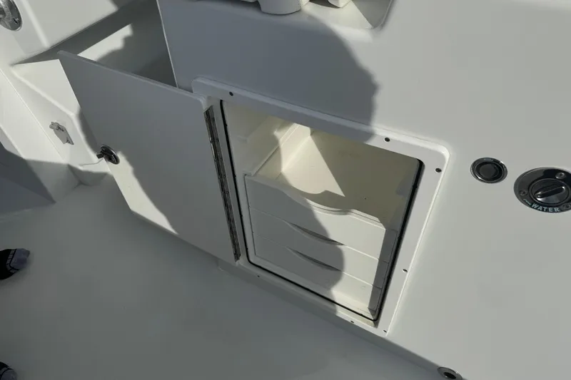 Slide: The Image of Open storage compartment on a 2022 Freeman 34VH boat, showing interior drawers. - 13