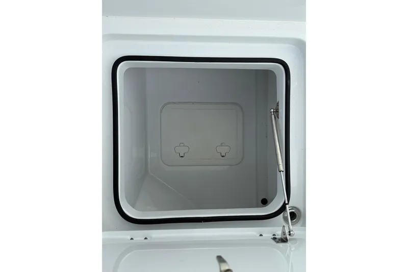 Slide: The Image of Open storage compartment on a 2022 Freeman 34VH boat, featuring a secure latch and hydraulic support. - 18