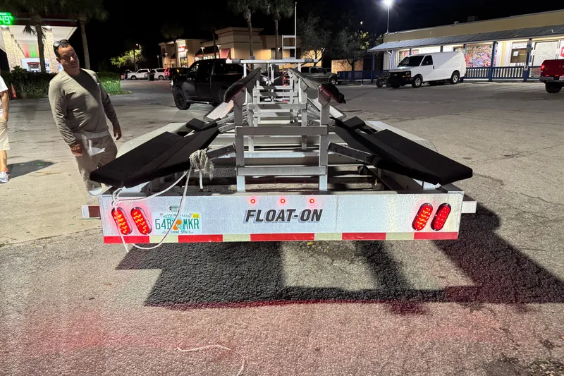 Slide: The Image of Freeman 34VH 2022 boat trailer at night, featuring Float-On design and Florida license plate. - 31