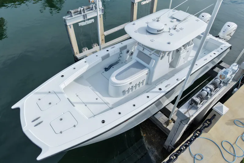 Slide: The Image of 2022 Freeman 34VH boat docked, showcasing sleek design and dual outboard motors. - 5