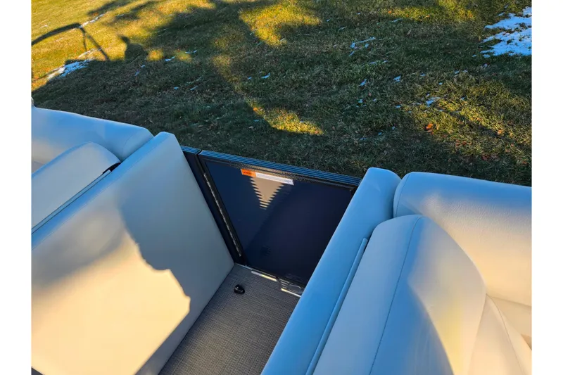 Slide: The Image of 2022 Crest Classic LX 220 boat interior with beige seating and outdoor view. - 11