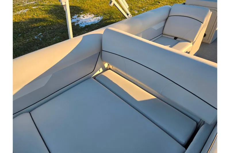Slide: The Image of 2022 Crest Classic LX 220 boat interior with beige seating and sunlight. - 19