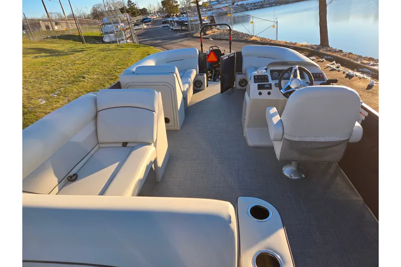 Slide: The Image of 2022 Crest Classic LX 220 pontoon boat interior with plush seating and steering console. - 20