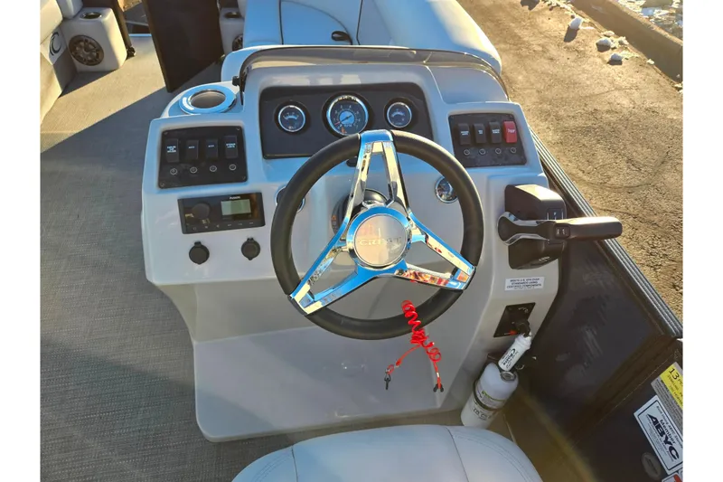 Slide: The Image of 2022 Crest Classic LX 220 boat dashboard with steering wheel and control panel. - 21