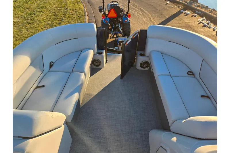 Slide: The Image of 2022 Crest Classic LX 220 pontoon boat interior with plush seating and open deck. - 23