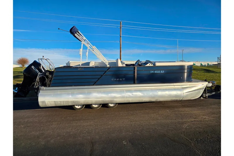 Slide: The Image of 2022 Crest Classic LX 220 pontoon boat with Suzuki outboard motor on a sunny day. - 4