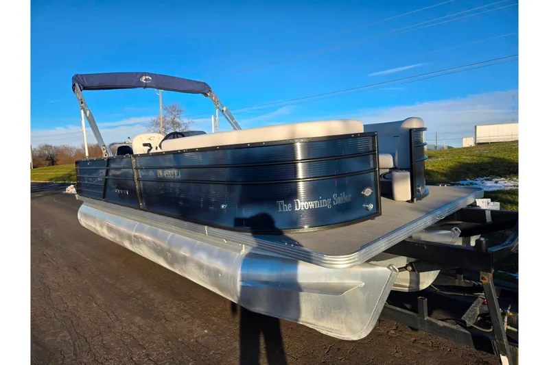 Slide: The Image of 2022 Crest Classic LX 220 pontoon boat on trailer under clear blue sky. - 5