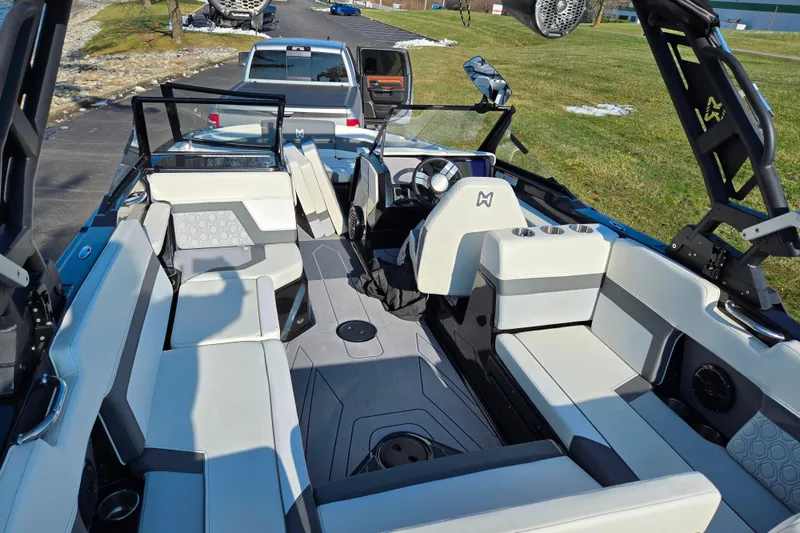 Slide: The Image of 2023 Heyday H22 boat interior with modern seating and steering wheel, parked near a truck. - 10
