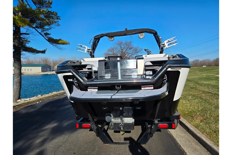 Slide: The Image of 2023 Heyday H22 boat rear view, parked by a lake under clear blue sky. - 2