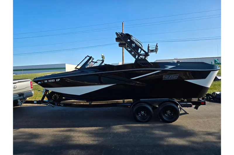 Slide: The Image of 2023 Heyday H22 boat on trailer, sleek black design, parked outdoors. - 4