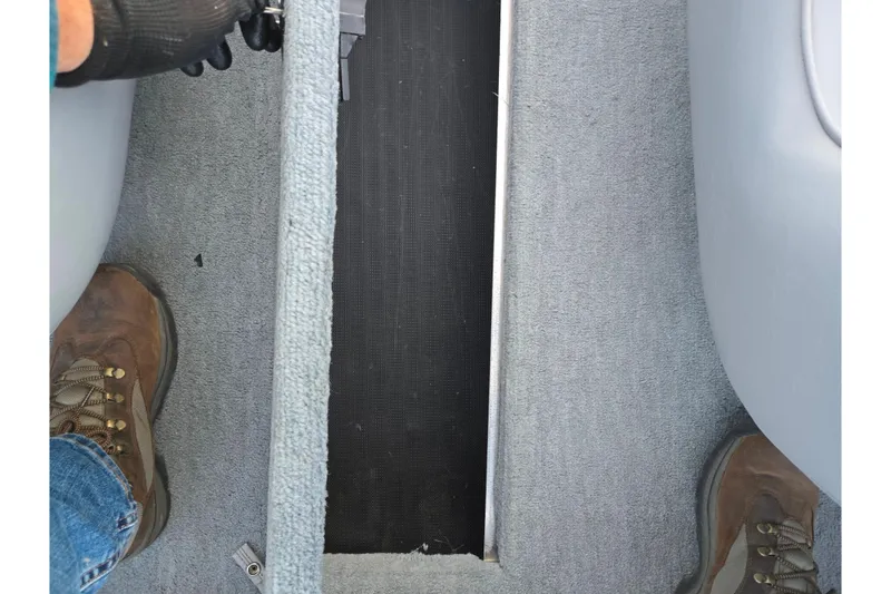 Slide: The Image of 1998 Stratos 290 Ski-N-Fish boat interior with carpeted flooring and boots visible. - 13