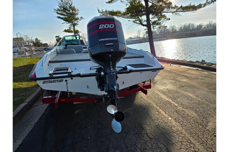 Slide: The Image of 1998 Stratos 290 Ski-N-Fish boat with Vindicator 200 engine by a lakeside. - 2