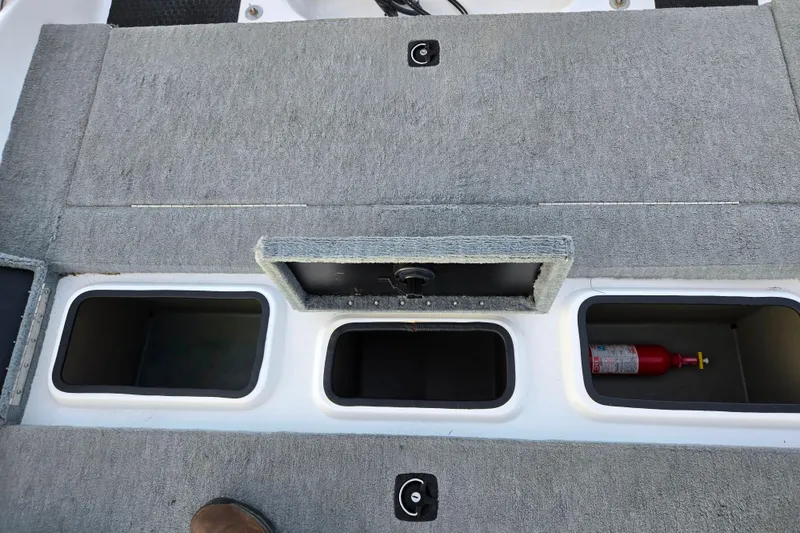Slide: The Image of 1998 Stratos 290 Ski-N-Fish boat storage compartments with fire extinguisher. - 25