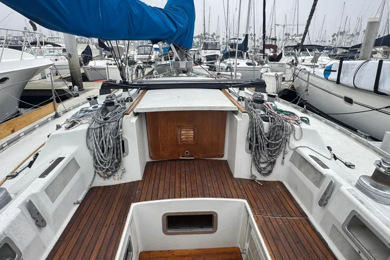 Slide: The Image of 1985 Beneteau First 38 sailboat cockpit with ropes and wooden deck in marina. - 16