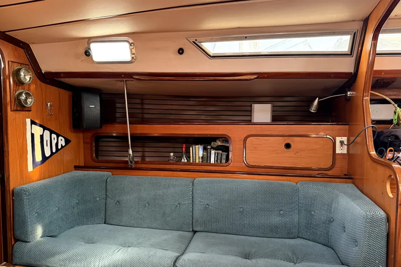 Slide: The Image of Interior of 1985 Beneteau First 38 sailboat with blue sofa and wooden cabinetry. - 22