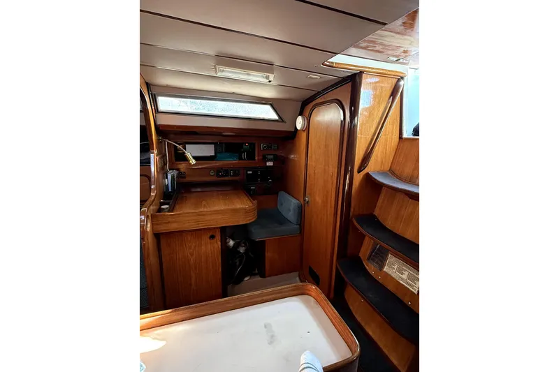 Slide: The Image of Interior of 1985 Beneteau First 38 sailboat with wooden cabinetry and seating area. - 25