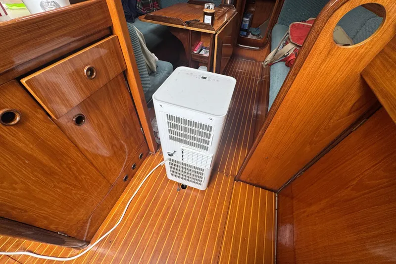 Slide: The Image of Interior of 1985 Beneteau First 38 sailboat with wooden flooring and a white appliance. - 27